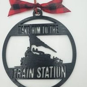 May include: Black wooden Christmas ornament with a silhouette of a train and the text "Take him to the train station".