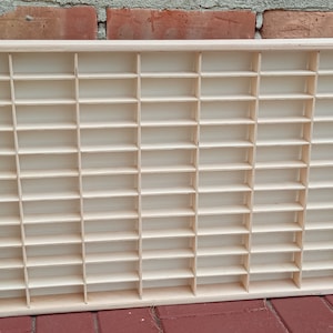 May include: A wooden display case with 72 individual compartments for storing small items. The case is made of light wood and has a natural finish.
