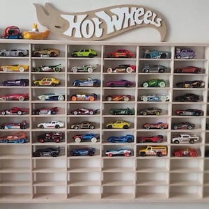May include: A wooden shelf unit with 72 individual slots for displaying Hot Wheels toy cars. The shelf is filled with a variety of colorful toy cars.