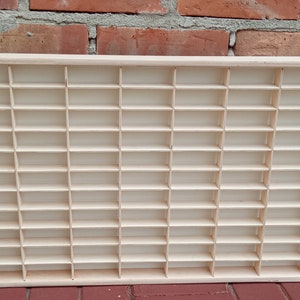 May include: A wooden display case with 60 individual compartments, perfect for organizing and showcasing small items.