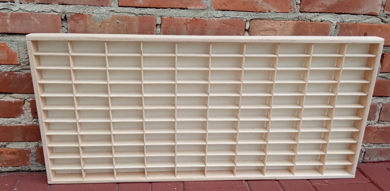 May include: A wooden display case with 60 individual compartments, perfect for organizing and showcasing small items.