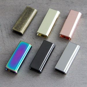 May include: Six metal slider buckles in different colors: antique brass, gold, rose gold, iridescent, black, and silver.
