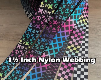 May include: Five different 1 1/2 inch wide nylon webbing ribbon trims. The ribbons feature a variety of colorful patterns including skulls, crosses, and checkered designs.  The text "1 1/2 Inch Nylon Webbing" is printed on the ribbons.