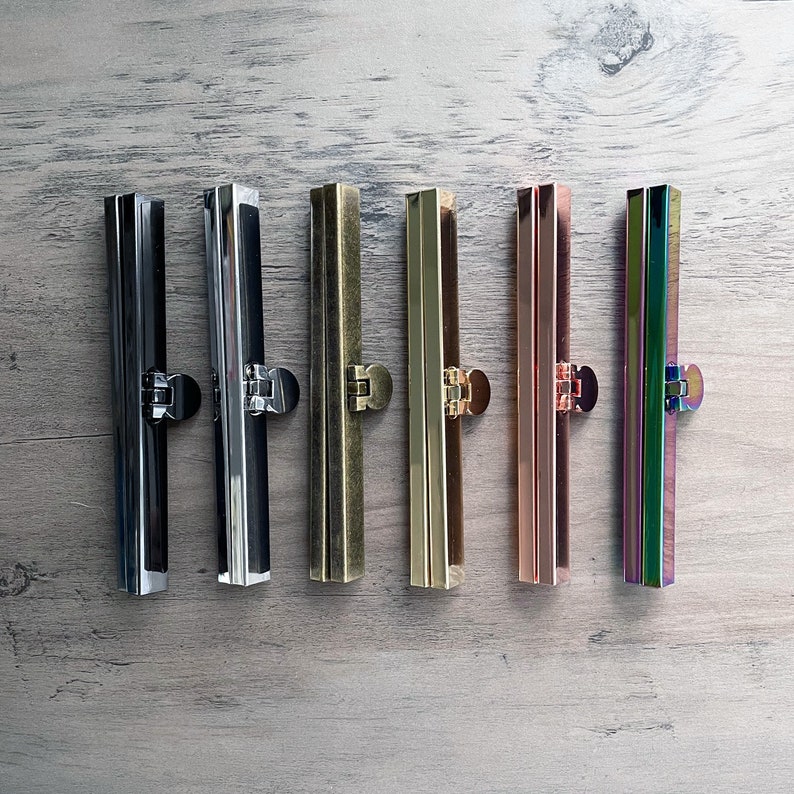 May include: Six metal purse frame clasps in different finishes: black, silver, brass, gold, rose gold, and iridescent.