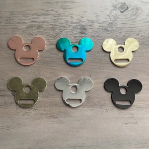 May include: Six metal Mickey Mouse-shaped charms in different colors: rose gold, teal, gold, silver, black, and antique brass.