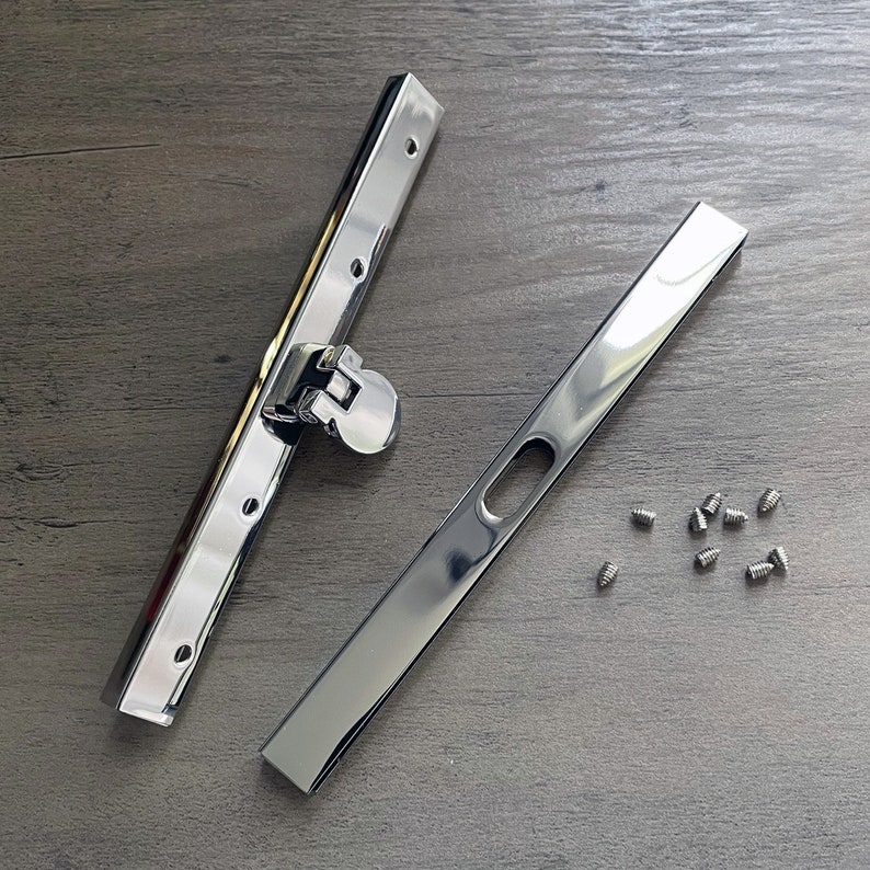 May include: Two silver metal purse frame pieces with a silver metal clasp and a set of small silver screws.