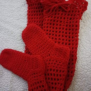 May include: A set of red crocheted slippers and a matching red crocheted top with a ruffled neckline.