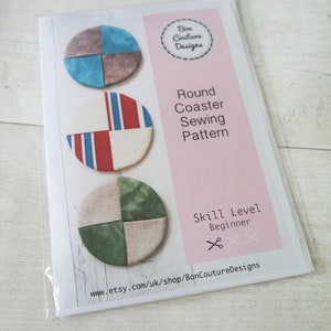 Pu&ograve; includere: Un modello di cucito per realizzare sottobicchieri rotondi in tessuto. Il modello include tre diversi design, ognuno con un diverso schema di colori. Il modello &egrave; etichettato "Round Coaster Sewing Pattern" e "Skill Level: Beginner".