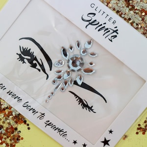 May include: A white card with the text "Glitter Spirits" and "You were born to sparkle..." printed on it. The card features a silver rhinestone design with two black eye silhouettes.