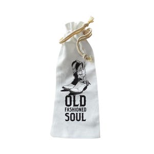 Puede incluir: Bolsa blanca con cordón, con una ilustración en blanco y negro de botas de vaquero. El texto "OLD FASHIONED SOUL" está impreso debajo. Cierre con cordón beige.
