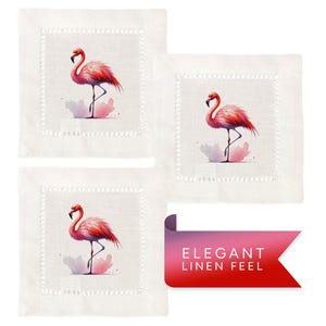 May include: Set of three white linen cocktail napkins with pink flamingo illustrations. Each napkin features a pink flamingo standing on one leg in a watercolor style. The napkins have a delicate white embroidered border.