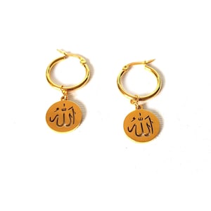 May include: A pair of gold hoop earrings with a dangling charm featuring the Arabic word "Allah" in a circular cutout design.