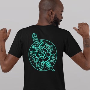 May include: A black t-shirt with a turquoise blue graphic of a rose and a dagger on the back. The front of the shirt has a smaller version of the graphic on the left chest.