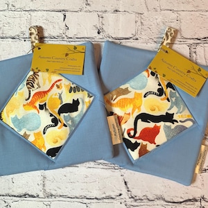 May include: Two light blue fabric pouches with a cat pattern. Each pouch has a tag that reads "Autumn Country Crafts". The cat pattern includes orange, black, and yellow cats on a white background.