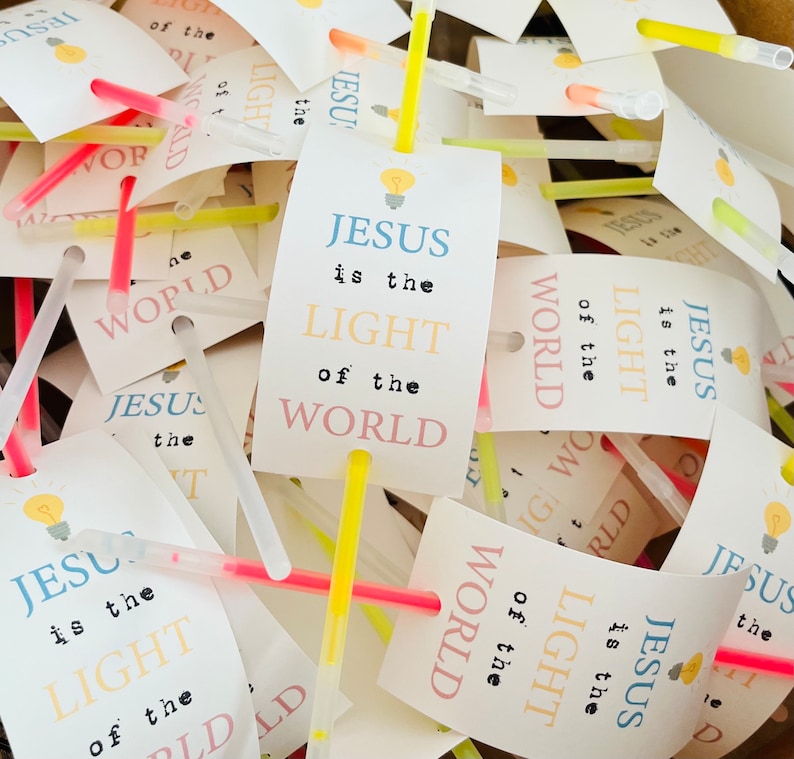 May include: A pile of glow sticks with tags that say "Jesus is the light of the world". The tags are in various colours, including pink, blue, and yellow.