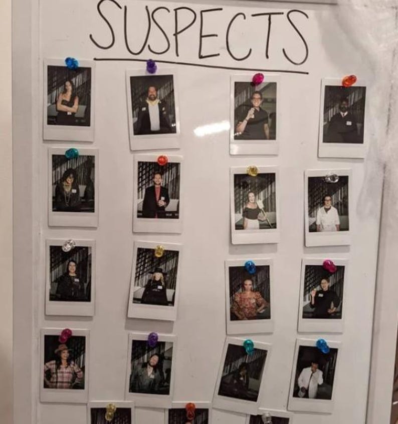 May include: A white board with the word "SUSPECTS" written in black marker. There are 16 Polaroid photos pinned to the board, each featuring a different person.