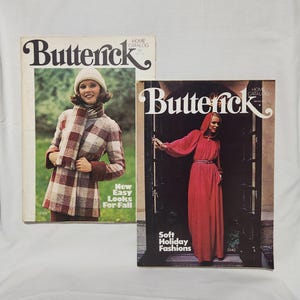 May include: Two vintage Butterick Home Catalog magazines. The magazine on the left features a woman wearing a plaid coat and scarf. The text reads "New Easy Looks For Fall". The magazine on the right features a woman wearing a long red dress. The text reads "Soft Holiday Fashions".