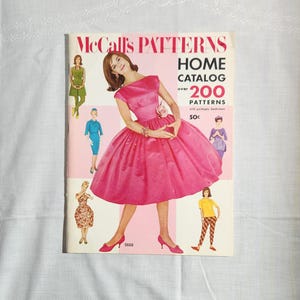 May include: A vintage McCall's Patterns Home Catalog featuring over 200 patterns with a pink background. The cover features a model wearing a pink dress with a white flower.
