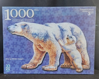 Puede incluir: Un rompecabezas de 1000 piezas con forma de rompecabezas que representa un oso polar y su cachorro. El rompecabezas terminado mide más de 90 cm. Se incluyen más de 30 imágenes ocultas.