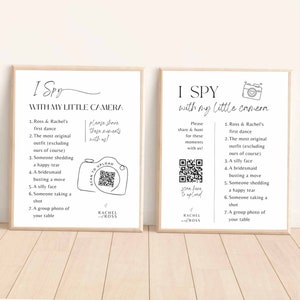 May include: Two printable cards with a black and white camera illustration and text that reads "I Spy with my little camera". The cards list seven things to find in a photo, such as "Ross & Rachel's first dance" and "A group photo of your table". The cards also include a QR code and the text "Scan here to upload" and "Rachel & Ross".