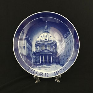May include: A blue and white ceramic plate with a picture of a church building and the text "Julen 1970".