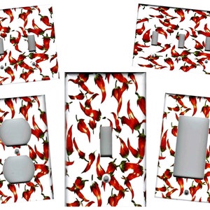 May include: Five different light switch and outlet covers with a red chili pepper pattern. The covers are white with a red chili pepper pattern.