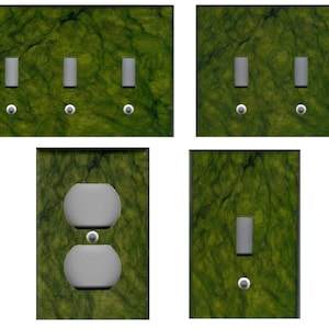 May include: Set of five light switch and outlet covers featuring a green marble pattern. The covers include a three-gang switch, a two-gang switch, a single switch, and a double outlet.
