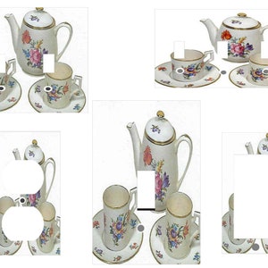 May include: A set of four light switch and outlet covers featuring a vintage floral teapot and teacups on a white background.