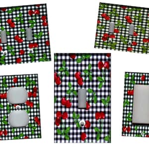 May include: Set of five light switch and outlet covers featuring a black and white gingham pattern with red cherries.