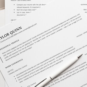 May include: A close-up of a resume with the heading "Taylor Quinn" and contact information. The resume includes a professional profile section and a work experience section.