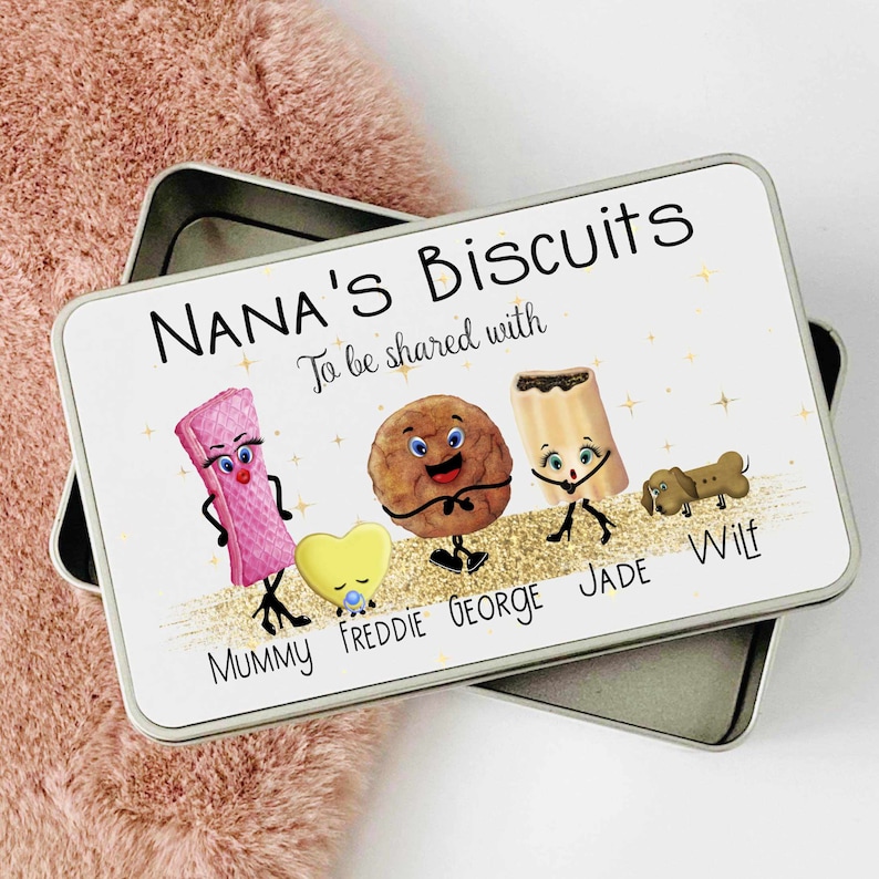 May include: White metal tin with a gold glitter background. The tin has the text "NANA'S Biscuits To be shared with" and features cartoon biscuits with faces and names: Mummy, Freddie, George, Jade, and Wilf.