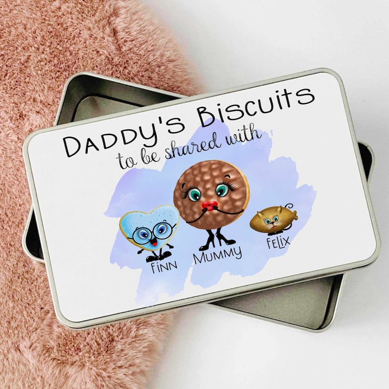 May include: White metal tin with a blue watercolor background and the text "Daddy's Biscuits to be shared with..."  Three cartoon biscuits are shown with the names "Finn", "Mummy", and "Felix" written below them.