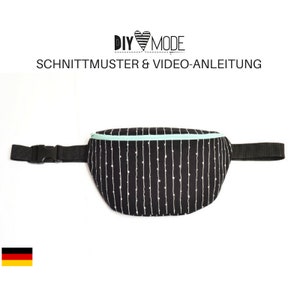 Könnte beinhalten: Schwarze Bauchtasche mit einem weißen und schwarzen Streifenmuster und einem hellblauen Reißverschluss. Die Bauchtasche hat einen schwarzen verstellbaren Gurt mit einer Schnalle.