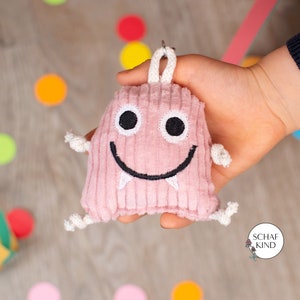 Mutmonster, Glücksbringer, Anhänger für Schulkinder aus kuschligem Baumwoll-Cord-Stoff in Rosa mit Geheimfach und Karabinerhaken, ca. 7x7 cm
