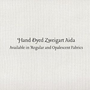 May include: Close-up of a textured, off-white fabric. The text "Hand Dyed Zweigart Aida" is displayed in elegant script, with the additional text "Available in Regular and Opalecent Fabrics" below.