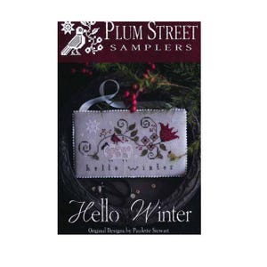 Può includere: Un libretto di schemi a punto croce intitolato Plum Street Samplers Hello Winter di Paulette Stewart. La copertina presenta un ricamo rettangolare con una pecora, un cardinale e motivi floreali, con il testo hello winter sottostante.