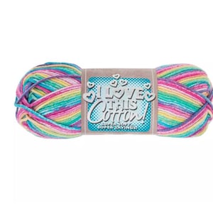 May include: A skein of variegated yarn featuring a blend of bright pink, yellow, teal, and purple colours. A central paper label displays the text I LOVE THIS COTTON! SUPER SOFT SUPER SAVINGS! surrounded by small heart icons on a blue dotted background.