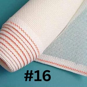 May include: A roll of off-white needlepoint canvas fabric featuring a grid pattern with a distinct orange thread woven along the edge. The fabric is partially unrolled, revealing the mesh structure. The number #16 is printed in black below the roll.