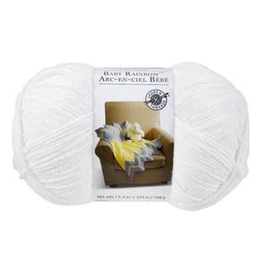 May include: A large ball of white yarn with a label that reads "BABY RAINBOW ARC-EN-CIEL BÉBÉ". The label shows a small chair with a yellow and gray blanket and a stuffed animal. The yarn is 364 yards / 5.3 oz / 333 m / 150 g.