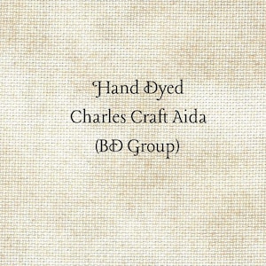 May include: A piece of beige Aida fabric with a visible woven grid texture. The text printed in the center reads: Hand Dyed, Charles Craft Aida, (BD Group). The fabric has a light, neutral tone with subtle variations in color across the surface.