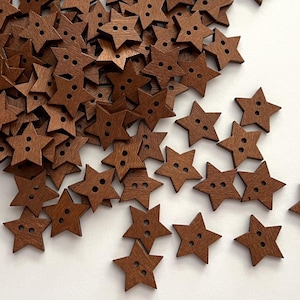 May include: A large collection of small, star-shaped buttons made of brown wood. Each button features a five-pointed star design with two holes in the center for threading. The buttons are scattered across the frame, showing a consistent dark wood grain texture and a flat, uniform finish on the surface of each individual piece.