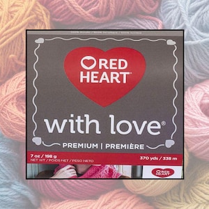 May include: A box of Red Heart "with love" premium yarn. The box features a red heart logo and the text "with love" in white. It contains 7 oz / 198 g of yarn and 370 yds / 338 m. The background shows various yarn colors.