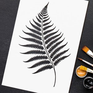 May include: A black and white fern leaf illustration on a white sheet of paper.