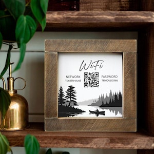 May include: A wooden framed sign with the word "Wifi" at the top. The sign displays network and password information with QR codes. A black and white landscape scene of a lake and trees is at the bottom.