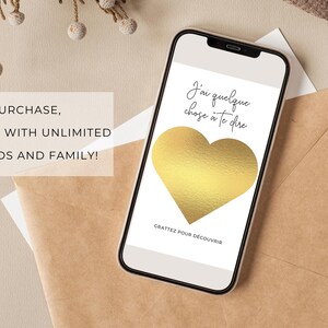 May include: A gold heart scratch-off card with the text "J'ai quelque chose &agrave; te dire" and "GRATTEZ POUR D&Eacute;COUVRIR" in French. The card is on a white background.