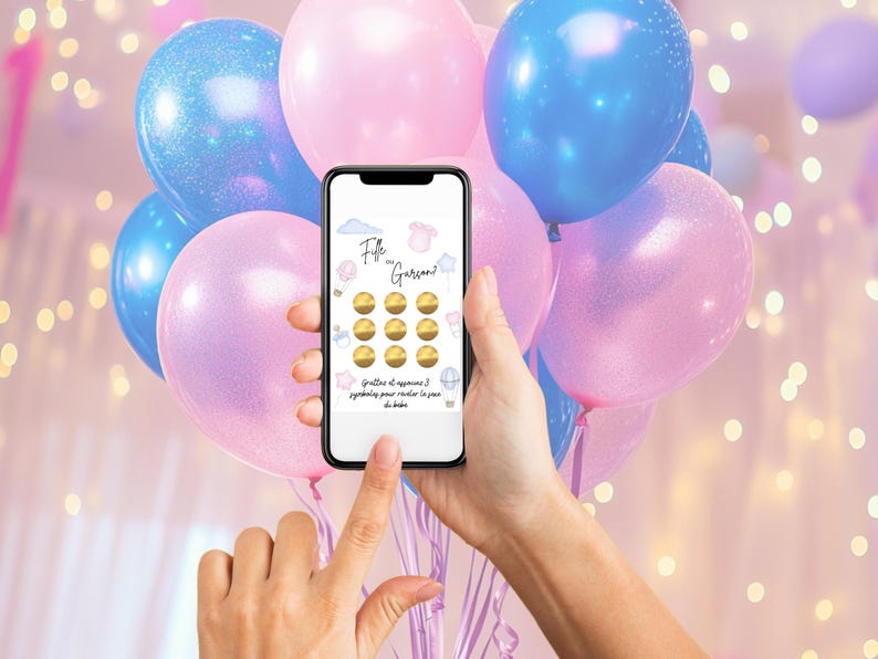 May include: A smartphone displays a gender reveal game with the text "Fille ou Gar&ccedil;on?" surrounded by pink and blue balloons. The game features scratch-off circles and baby-themed icons. The background includes more balloons.