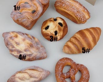 May include: Seven different types of bread and pastry, including a croissant, pretzel, and a loaf of bread with a swirl design. Each item is numbered 1 through 7.