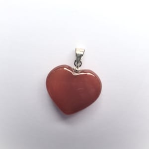 May include: A heart-shaped pendant made of carnelian, a reddish-orange gemstone, with a silver bail.