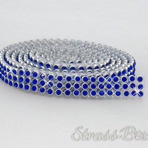 Puede incluir: Un rollo de ribete de strass azul con respaldo plateado. El ribete está hecho de pequeños strass redondos que están muy juntos.