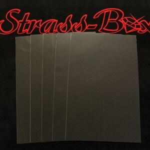 May include: Six sheets of black adhesive-backed felt paper. The felt is smooth and has a subtle texture.